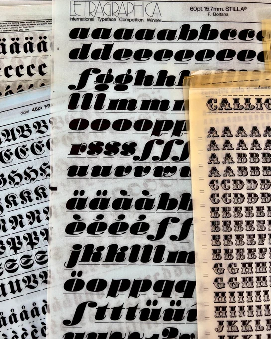 Examples of dry transfer type from Letraset and other brands. Black letters on white paper.