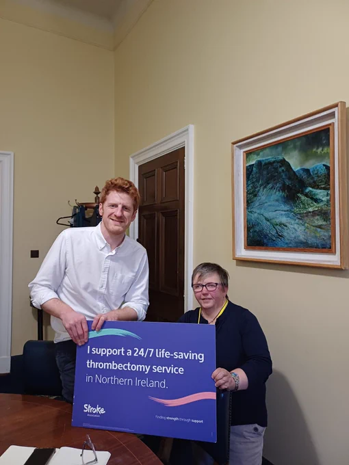 Matthew and Pam Tilson ftom Stroke Association.  Mathhew holding a banner pledging support for a 24/7 thrombectomy service in NI