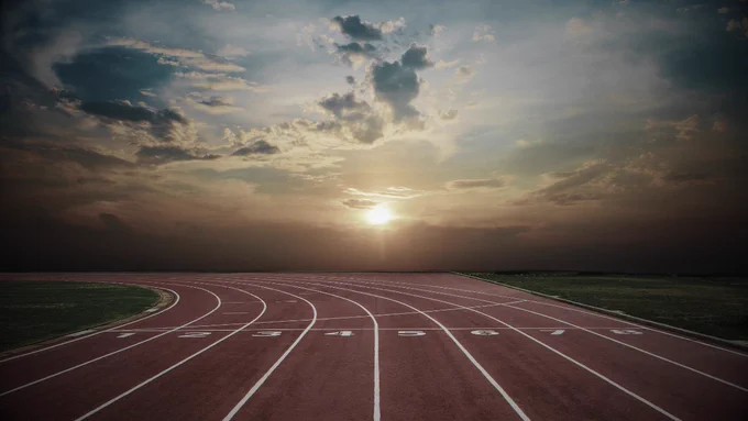 An empty running track at sunrise symbolizes failure, perseverance, and return.