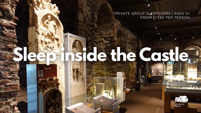 Interior view of Colchester Castle museum gallery with Roman stone carvings and artifacts displayed in glass cases along a brick wall. Large white text reads “Sleep inside the Castle,” promoting private group sleepovers for ages 5  from £17.50 per person. Smaller text at the bottom says “After hours at Colchester Castle.”