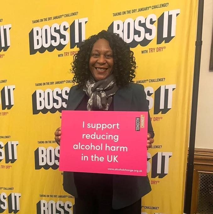 Juliet Campbell holding a sign that says "I support reducing alcohol harm in the UK"