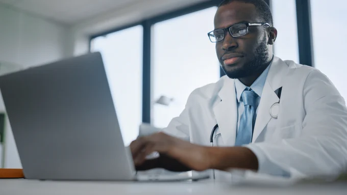 Physician uses laptop to take Accreditation 360 on demand webinar
