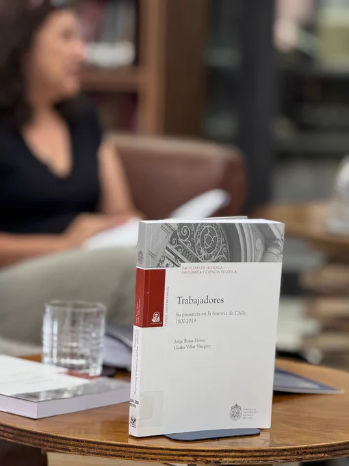 Imagen que muestra libro sobre historia de las y los trabajadores sobre mesa en Sala Chile, lugar donde se efectuó la presentación del texto.