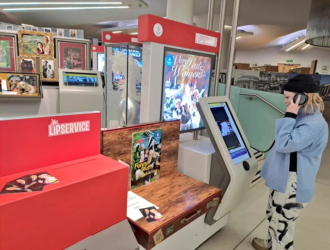 Woman listening in and watching a exhibition screen 