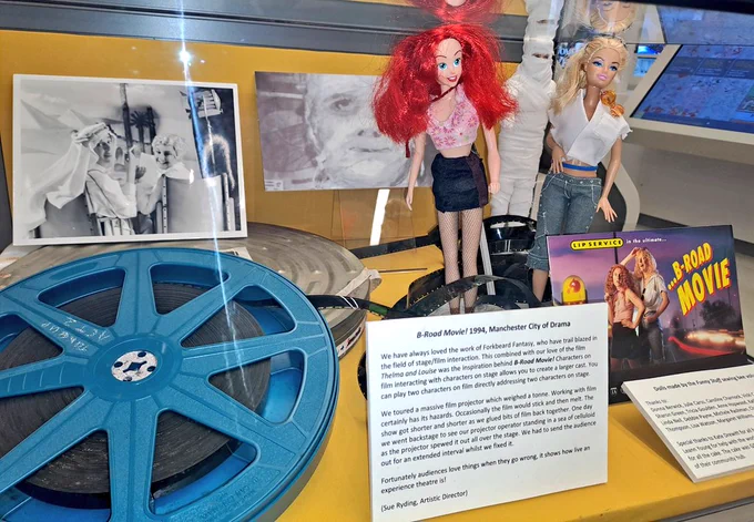 Glass case showing film reel, historic photos and Barbie dolls dressed as Thelma and Louise 