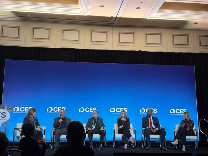 Photo of 6 people talking on a panel at CES. 