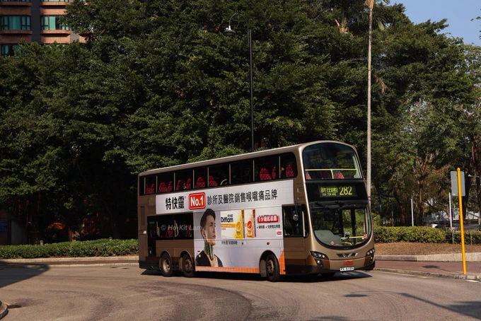 Kowloon Motor Bus AVBWU144 (PX 6189) is a gold and brown Volvo B9TL Gemini 2 and is pictured in Sha Tin as it heads to Sun Tin Wai on route 282.