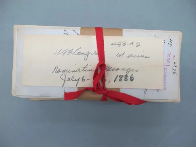 Original red tape keeping a bundle of documents together. Photo by the National Archives