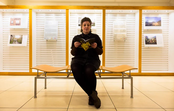 A woman sits on a sit in the middle of an exhibition on Seasonal Affective Disorder (SAD)