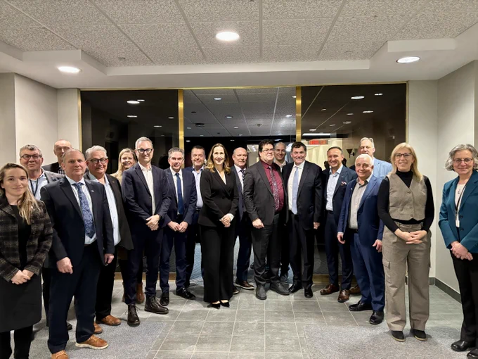Minister Dominic LeBlanc poses for a group photo with representatives from the dairy and aluminum industries in Montreal.