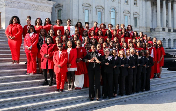 Rep. Summer Lee poses with the Deltas on the Capitol steps. They are wearing red and black outfits.