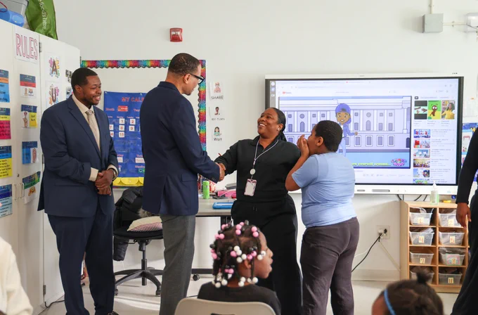 Chancellor Ferebee shakes hands with Ms. Marbury.