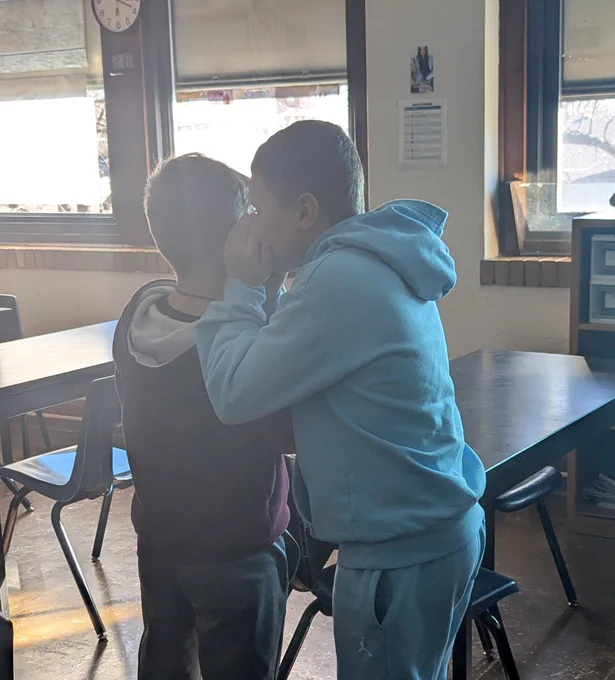 A student whispering to another student 