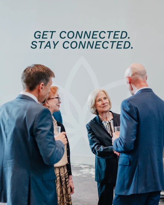 Group of four professionals in conversation at a networking event. In the background, text reads, "GET CONNECTED. STAY CONNECTED." Rowen logo underneath.