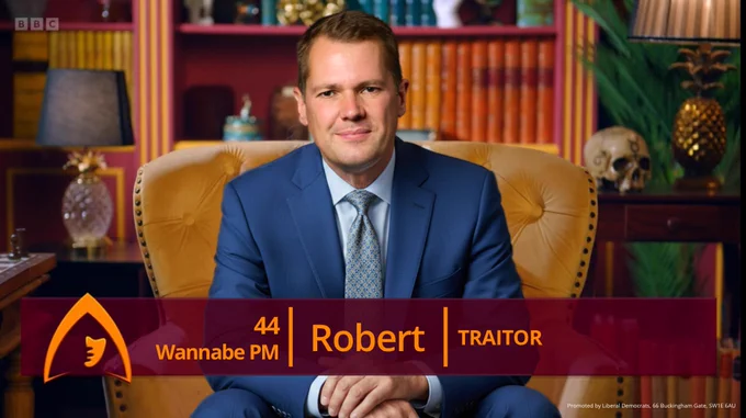 An edit of a 'Traitors' confessional shot with Robert Jenrick sat in the chair. The caption identifies him as 'Robert' 44, Wannabe PM and a traitor'. 