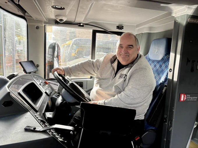 Ian sits in the drivers seat of a city link coach