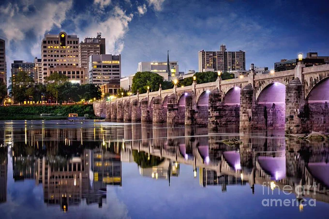 Harrisburg, the capital city of Pennsylvania. is a lovely town. The picturesque Market Street Bridge is shown here spanning the waters of the Susquehanna River. This postcard-type photograph was taken in late afternoon, and the reflection of the blue sky and bridge in the water was stunning. This artwork is from the Fine Art Gallery of Shelia Hunt.