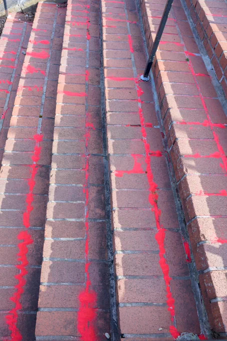 Photo showing red sand filling the cracks of brick steps following a Red Sand Project event at BWI Thurgood Marshall Airport.