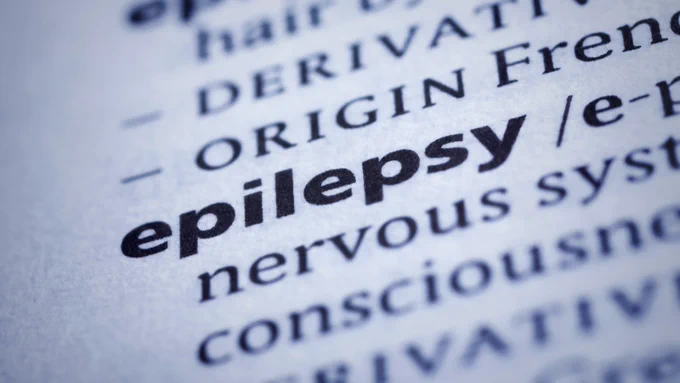 Close-up of a dictionary page highlighting the word 'epilepsy' in bold with surrounding medical text.