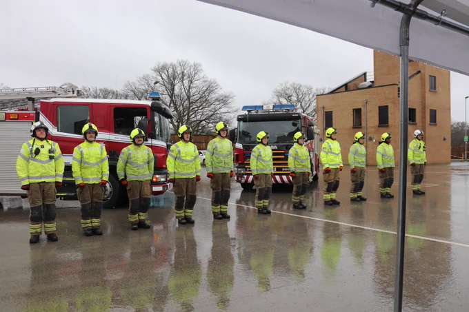 New firefighters lined up in front of fire engines