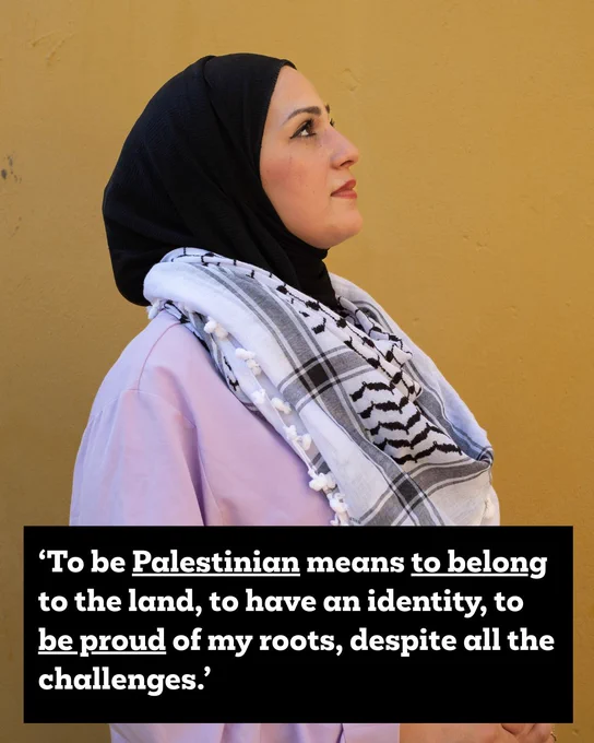 ‘To be Palestinian means to belong to the land, to have an identity, to be proud of my roots, despite all the challenges.’
Fidaa is wearing an Palestinian keffiyeh around her neck. She is stood beside a yellow wall looking upwards. 
