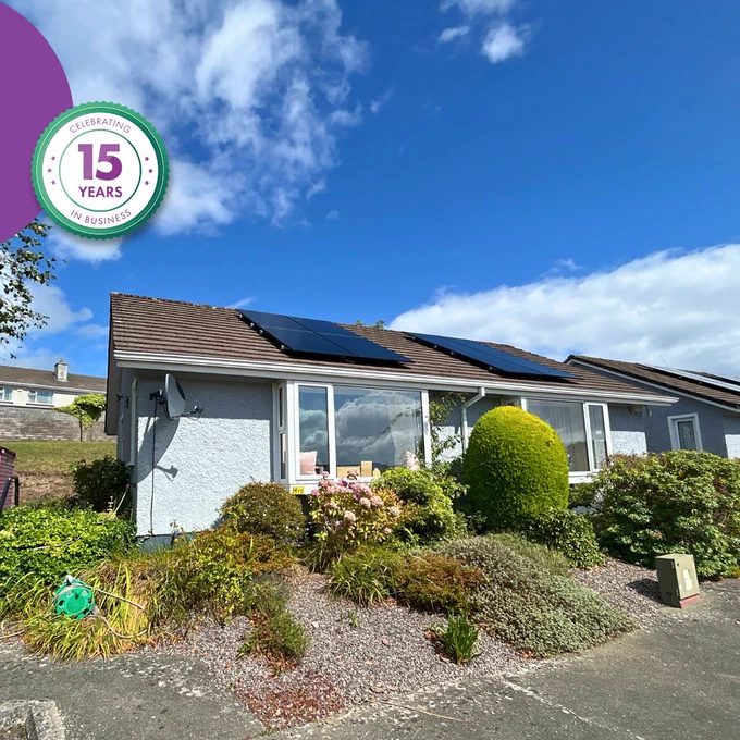 Retrofitted bungalow with solar PV panels, new windows and landscaped garden following energy efficiency upgrades.