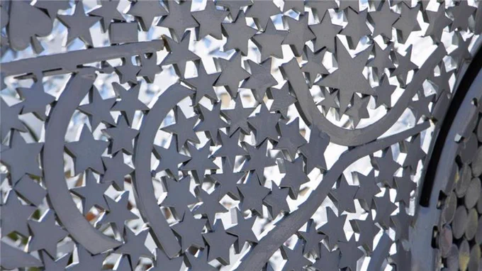 Decorative metal fence with intricate patterns of stars and crescents.