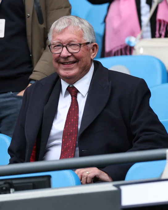 Sir Alex Ferguson smiles from the directors' box at the Etihad Stadium.