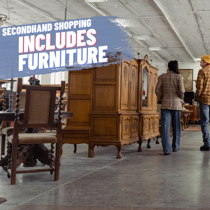 There are 2 people walking away from the camera, in a furniture shop or warehouse. The furniture is all antique style.