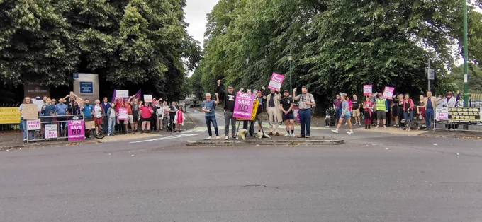 A photograph of a picket line filled with UCU signs at the University of Nottingham south entrance.