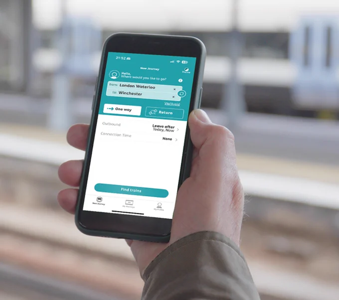 Hand holds out smart phone displaying the Passenger Assistance app on its screen.