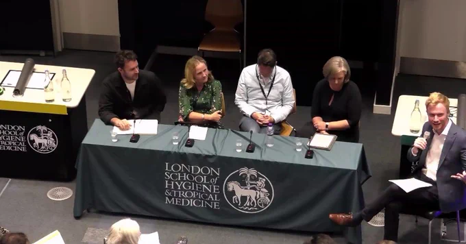 Adam Kucharski from LSHTM introducing panelists  during a session as part of Health Information UNPACKED. The LSHTM logo can be seen on tablecloth in front of the speakers.