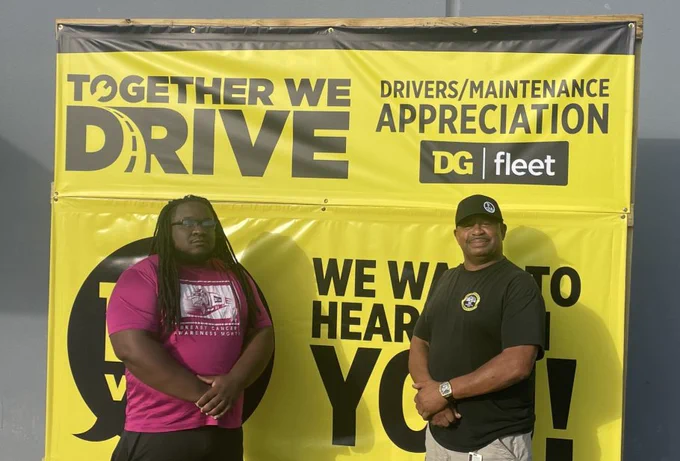 2 people standing in front of a yellow Dollar General sign.