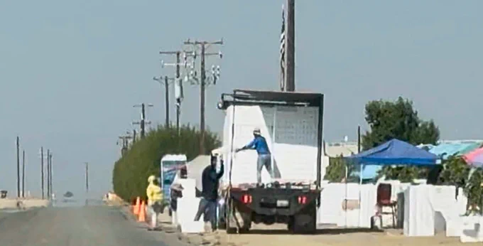 Farm workers loading a truck full of harvested grapes