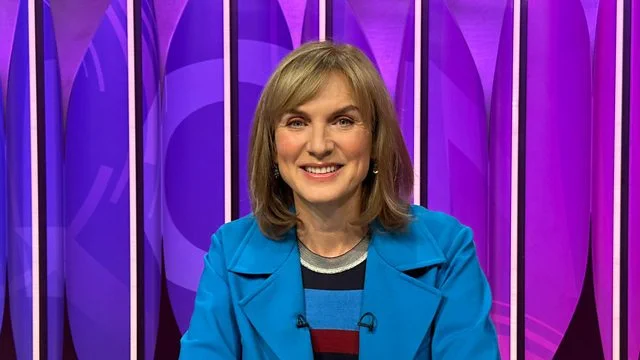 Fiona Bruce wearing a blue coat against the Question Time background