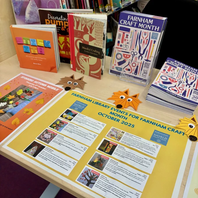A table of posters about Farnham Craft Month, with the official brochures in a pile.