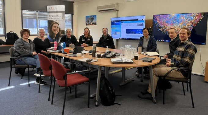 The participants of the Canberra Hub sit around a conference table to participate remotely in the ESIP July Meeting.