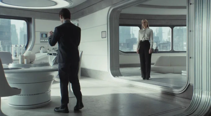 A scene from Andor A Star Wars Story. Syril unpacks a grocery bag on the kitchen table while talking to Dedra