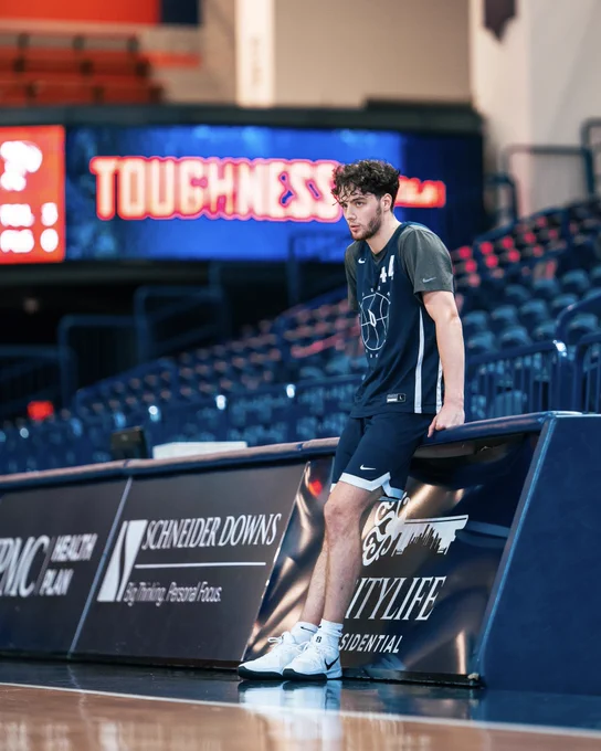 Jake DiMichele leaning on table at practice
