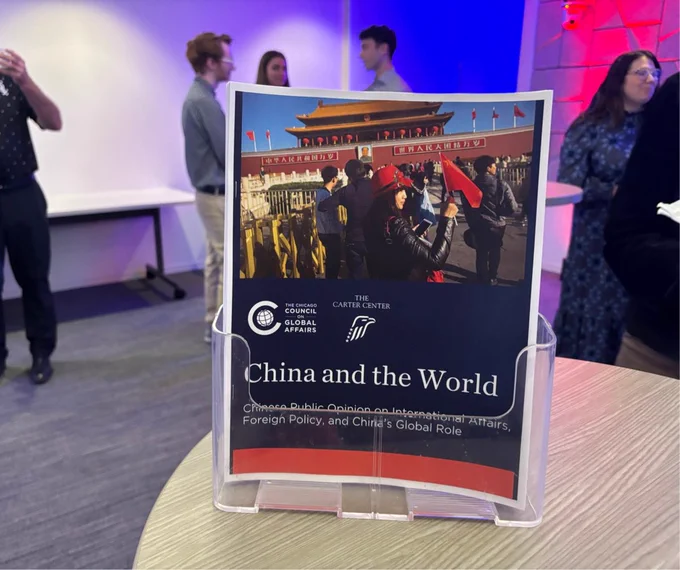 A printed copy of the "China and the World" survey report resting in a plastic stand on top of a table.