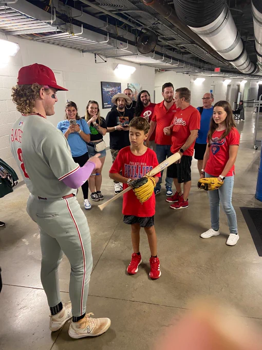 Harrison Bader signs his bat for the kid. He's wearing the grey Phillies uni.