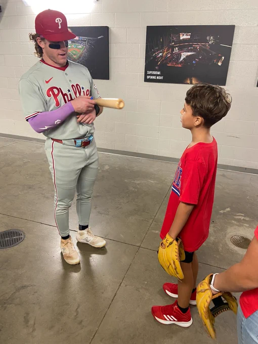 Harrison Bader signs his bat for the kid. He's wearing the grey Phillies uni.