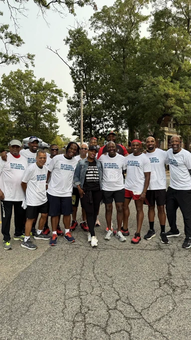 Rep. Pressley in a hat and jean jacket with runners in athletic clothes, wearing shirts that say “Black men, you deserve to grow old.”