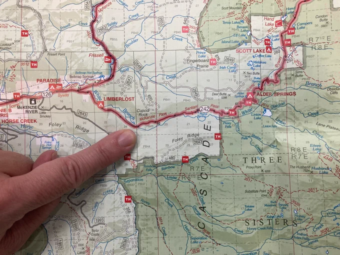A finger points on a map