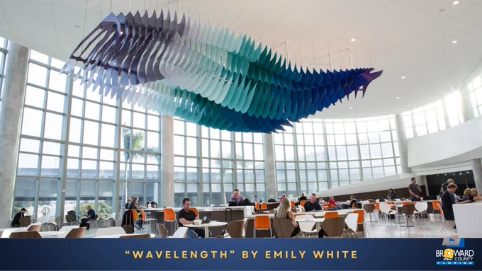 “Wavelength” by Emily White. Purple, white, aqua, teal, and blue sculpture hung from the ceiling in Terminal 1 Concourse A. 