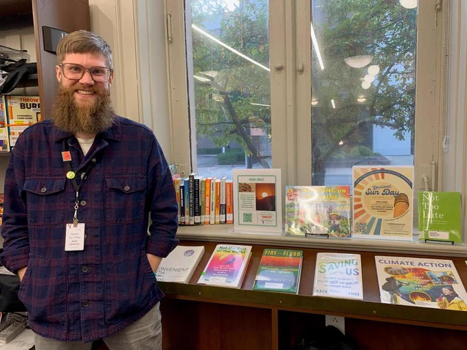 Ypsilanti library climate action display with a printout of event flyer for Sun Day 