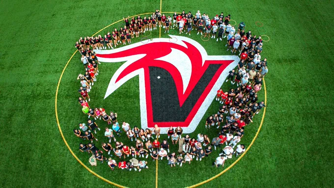 An aerial view of UH Hilo student-athletes on field with Vulcan logo.  