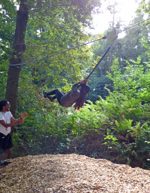 Staff enjoying a zip wire ride in a woodland