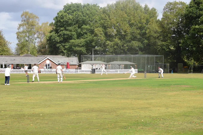 Naman hits ball in sunshine as bowler watches on