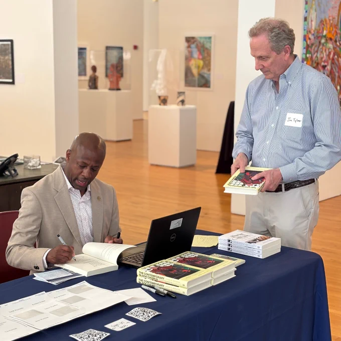 Sociologist Jason E Shelton autographing a copy of his book "The Contemporary Black Church" for a guest at Monday's event.